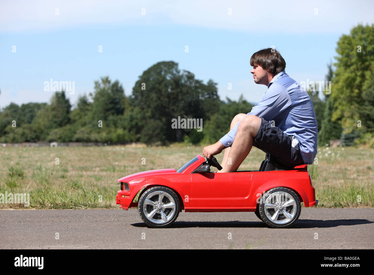 man-driving-a-small-car-BA0GEA.jpg